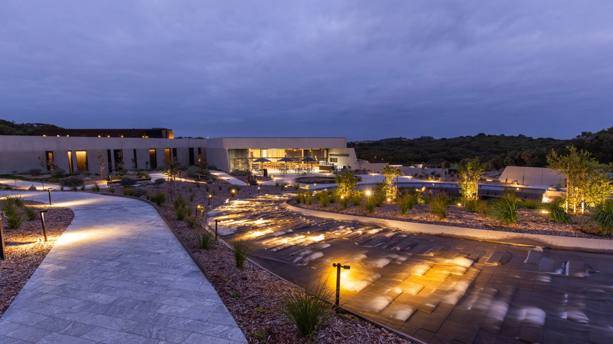 A lit hotel window at dusk on the Mornington Peninsula, the ridge in soft focus behind